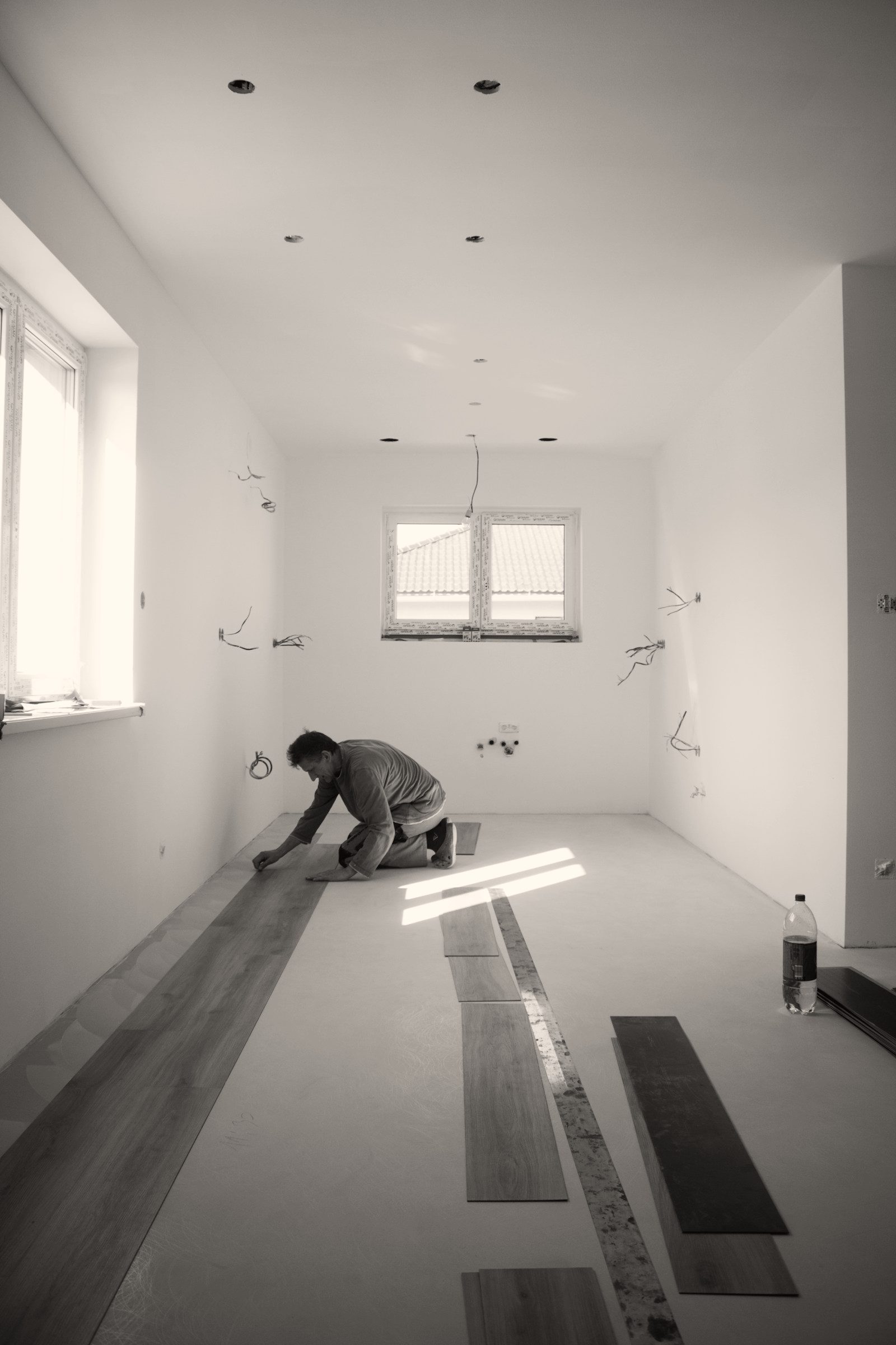 Vakman legt een nieuwe vloer in een lege kamer